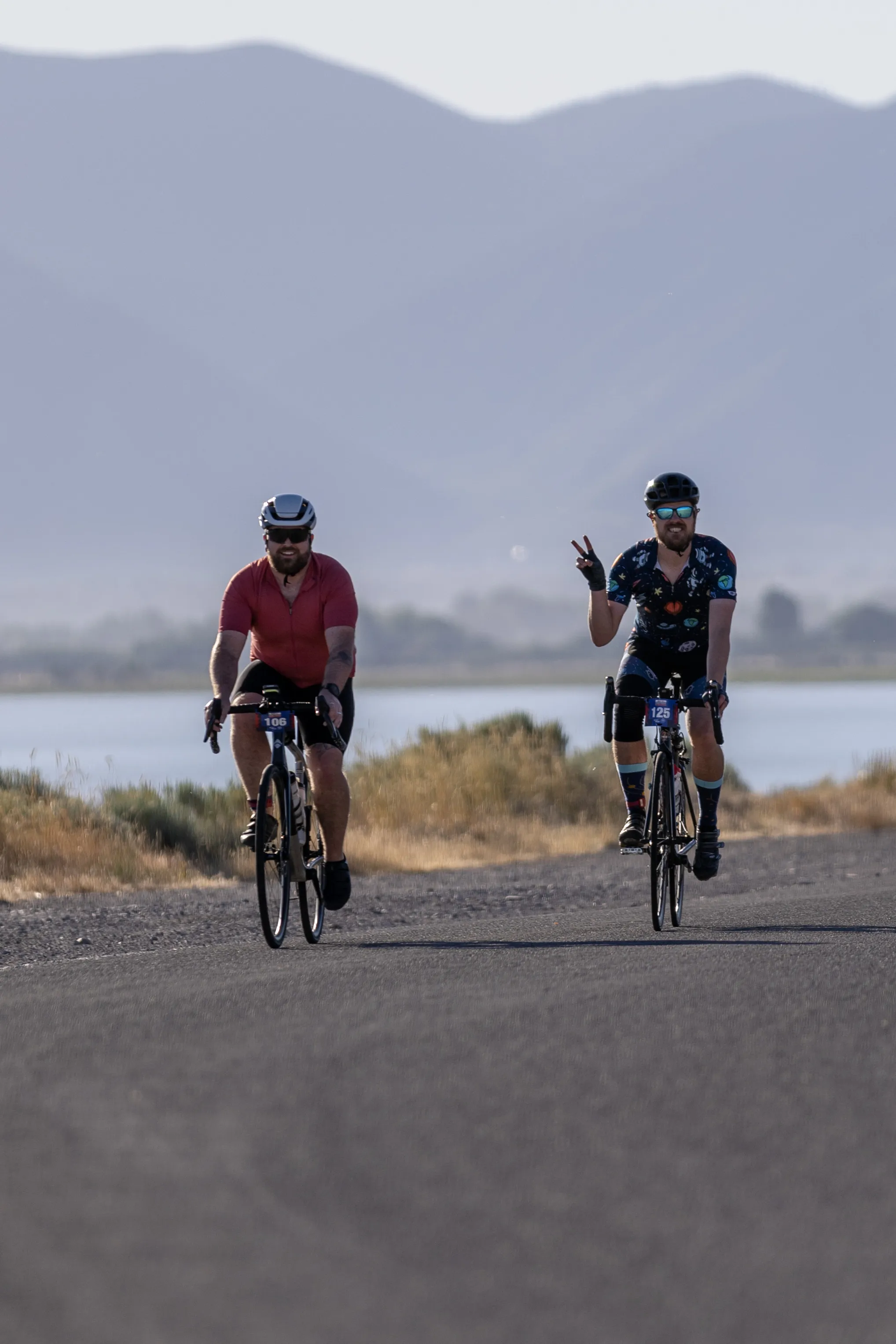 Ty and a friend riding a gran fondo route in front of Utah mountains
