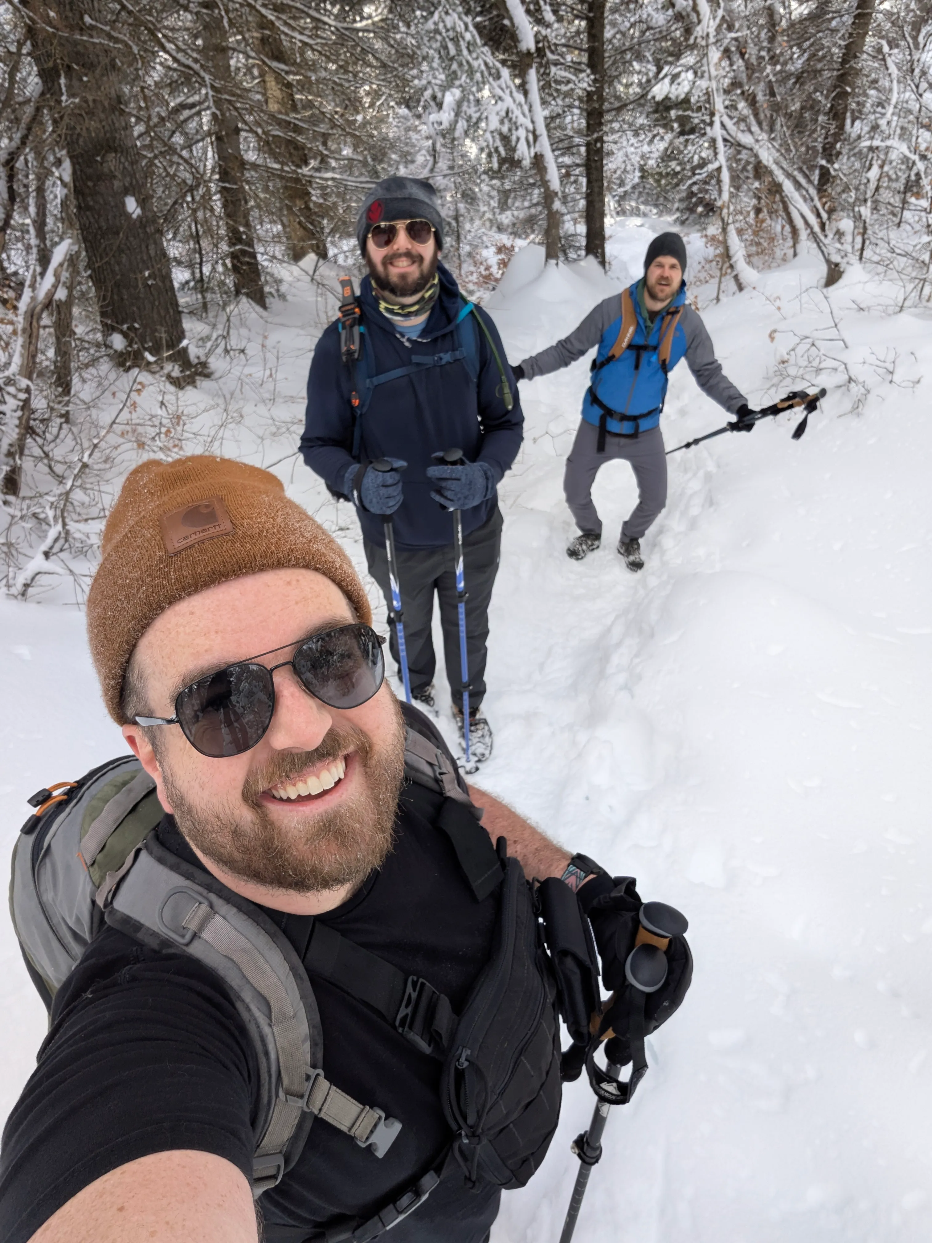 Ty snowshoeing with two friends on a snowy trail